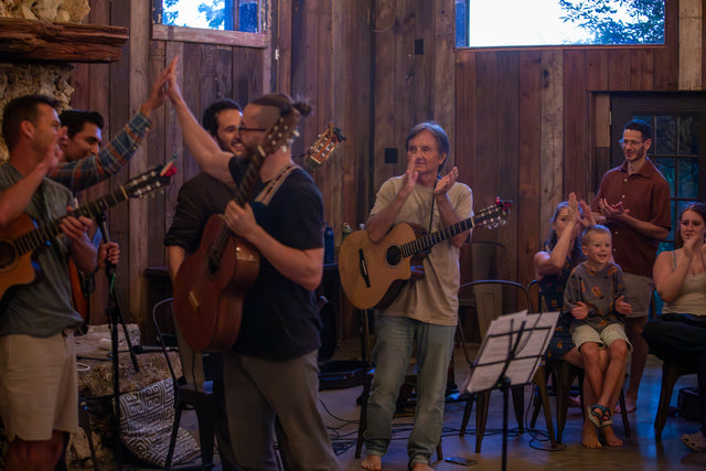 A trio of students singing and playing guitars at the final concert
